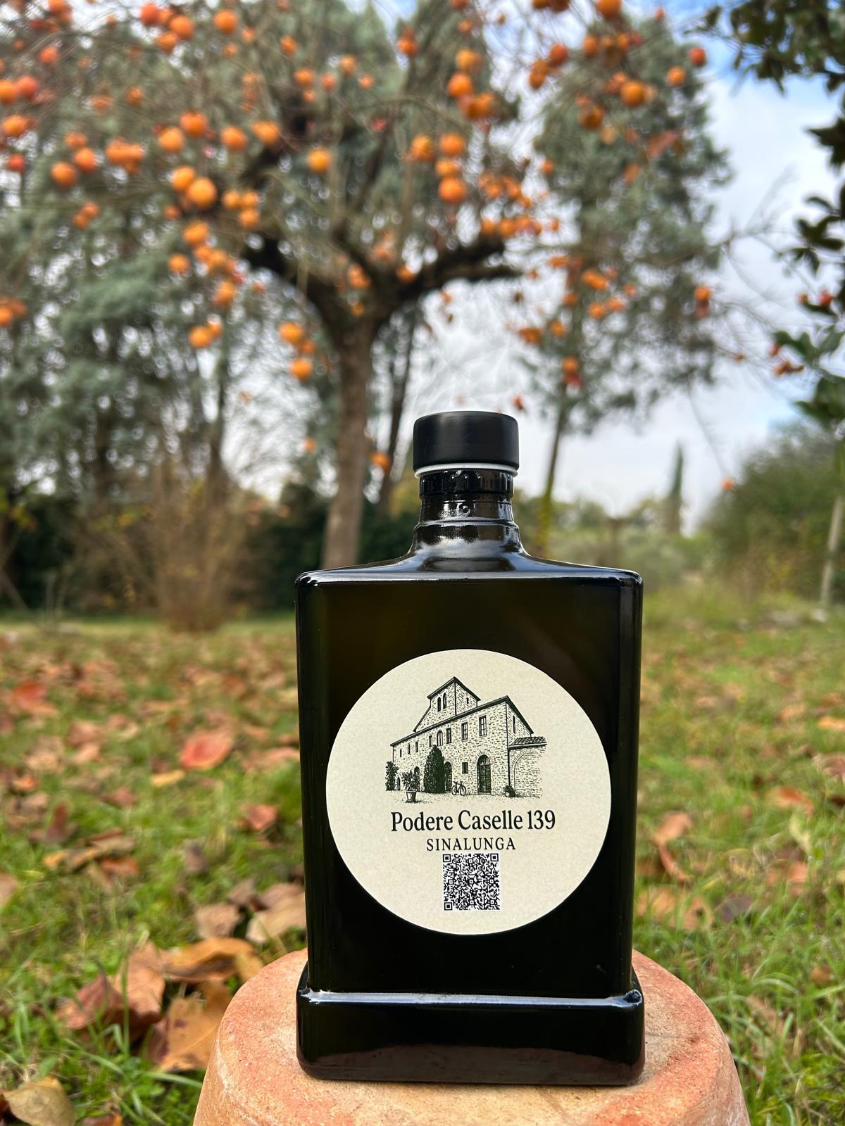 Una bottiglia di olio con i cachi sullo sfondo